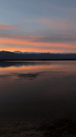 Stone thrown into water near Bansko mountains at sunset