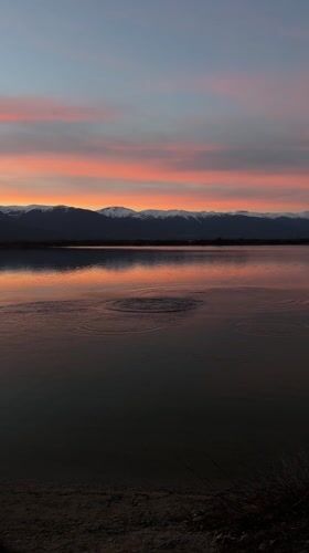 Stone thrown into water near Bansko mountains at sunset