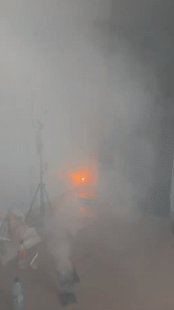 Smoke-filled ceremony with candles and white robes in Badagry