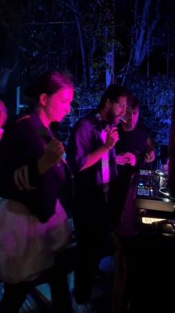 Woman with microphone performs alongside smoking DJ in Ko Samui