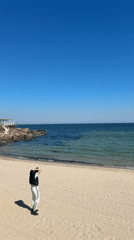 Person stands on sunny Sozopol beach under clear skies