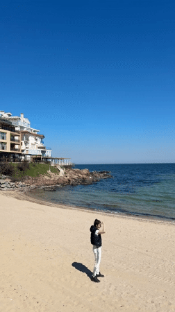 Person stands on sunny Sozopol beach under clear skies