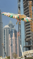Aerial acrobat performs over Dubai pool with inflatable decorations