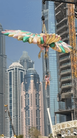 Aerial acrobat performs over Dubai pool with inflatable decorations