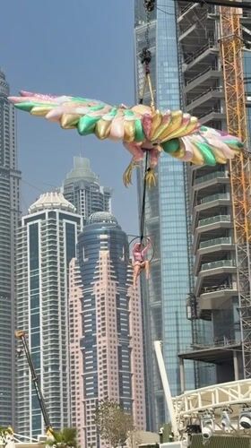 Aerial acrobat performs over Dubai pool with inflatable decorations