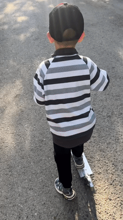 Kid on a scooter, summer streets in Novoaltaysk