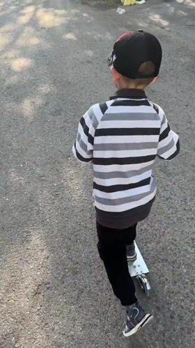 Kid on a scooter, summer streets in Novoaltaysk