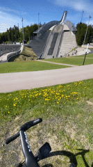 Cyclist rests near iconic Holmenkollen ski jump in Oslo