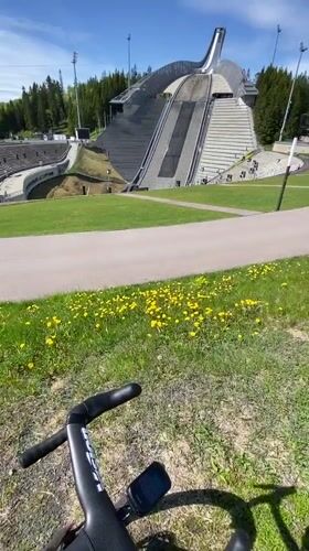 Cyclist rests near iconic Holmenkollen ski jump in Oslo