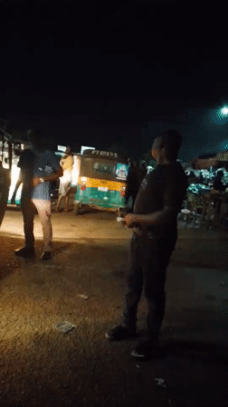 Nighttime street gathering with auto-rickshaws documented in Bukuru
