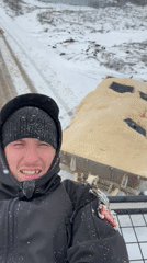 Person rides vehicle roof rack through snowy Sarapul streets