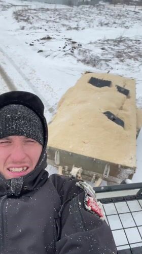 Person rides vehicle roof rack through snowy Sarapul streets