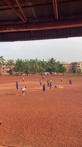 Soccer match played on red dirt field in Abakaliki