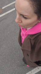 Woman in bright pink sneakers walks past child's drawing in Riga