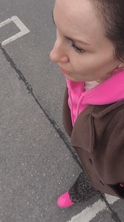 Woman in bright pink sneakers walks past child's drawing in Riga