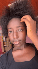 Woman takes selfies in pink-walled room in Abuja