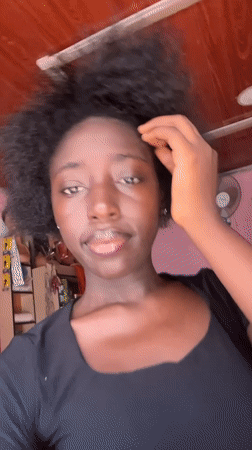 Woman takes selfies in pink-walled room in Abuja