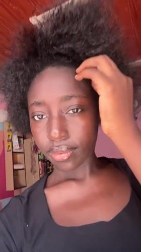 Woman takes selfies in pink-walled room in Abuja