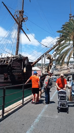 Tourist explores Genoa's port, aquarium, historic squares on sunny day