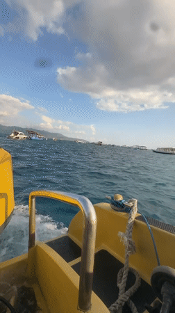 On the water in Indonesia, yellow boat moving through a busy anchorage