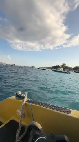 On the water in Indonesia, yellow boat moving through a busy anchorage