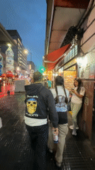 Two people walk through rainy Buenos Aires evening streets