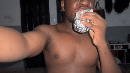 Man eats foil-wrapped meal in Gbongan room
