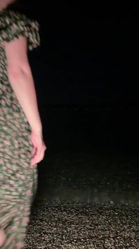 Woman in flower crown visits Montenegro beach at night
