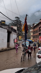 Street procession with drums and ritual elements in rainy Bhagsu