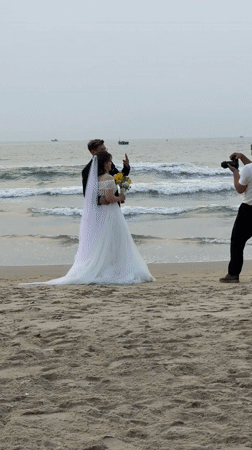Wedding couple poses for beach photos in Đà Nẵng