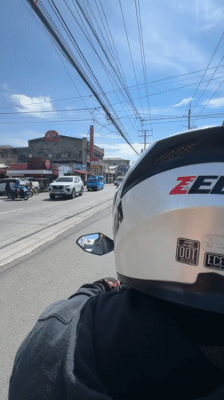 Motorcycle rider travels through sunny Davao City streets