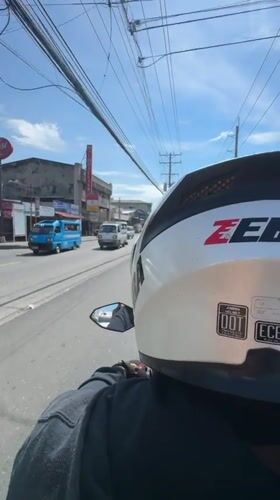 Motorcycle rider travels through sunny Davao City streets