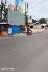 Motorcyclist transports gas tanks through Indonesian commercial district intersection