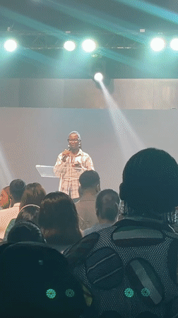 Podium speaker addresses packed indoor crowd in Jos, Nigeria