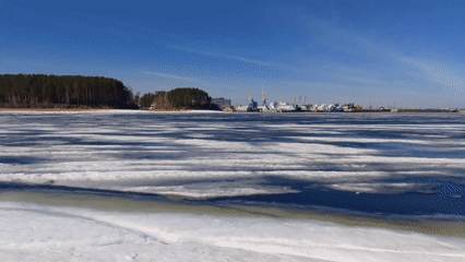Red-haired visitor documents frozen lake during early morning outing