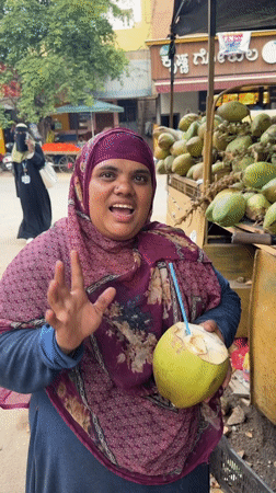 Woman enjoys coconut drink at street vendor in Bengaluru