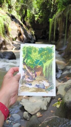 Artist paints watercolor studies of jungle stream in Sukawati