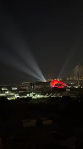 Illuminated bridge displays white and red lights in Loures nightscape