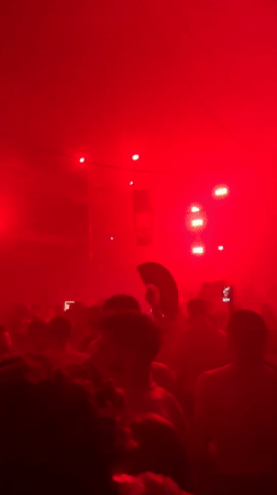 Crowd gathers in darkened venue with pulsating lights in Serbia