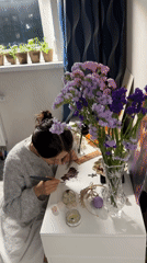 Woman draws by candlelight at desk in Murino
