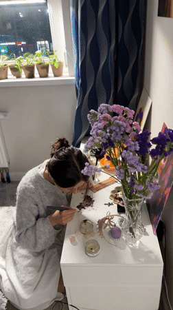 Woman draws by candlelight at desk in Murino