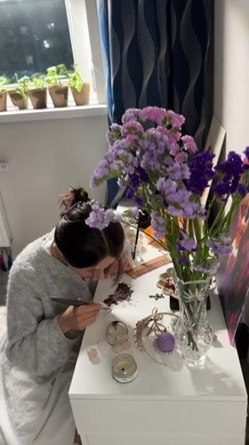 Woman draws by candlelight at desk in Murino