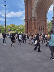 Diverse group performs synchronized dance at Barcelona's Arc de Triomf