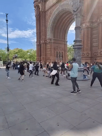 Diverse group performs synchronized dance at Barcelona's Arc de Triomf