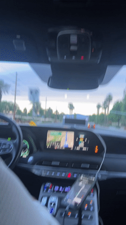 Driver navigates palm-lined road in La Quinta with dashboard map