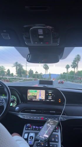 Driver navigates palm-lined road in La Quinta with dashboard map