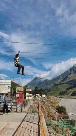 Zip-lining over a wide river in the Indian mountains