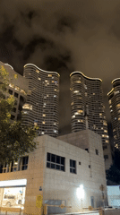 Illuminated undulating apartment towers captured at night in Tel Aviv