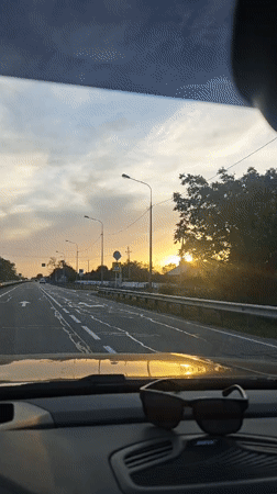 Car drives toward sunset on Russian highway