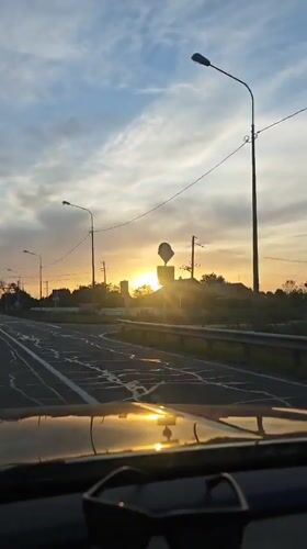 Car drives toward sunset on Russian highway